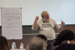 Image: Bill black discussing the recipe for fraud near a white board.