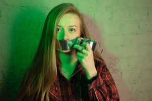 Picture of woman putting duct tape over her own mouth.