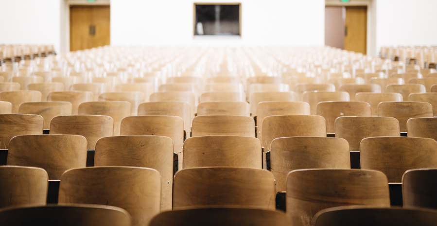 Image of empty wooden seats in a theater or classroom