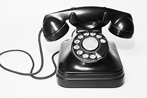 Photo of black rotary telephone.
