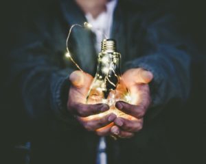 Man holding incandescent bulb.