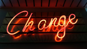 Image of a neon sign that says "Change" in a cursive font.