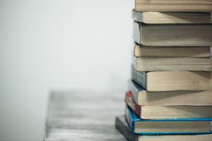Image of paperback books stacked on a table.